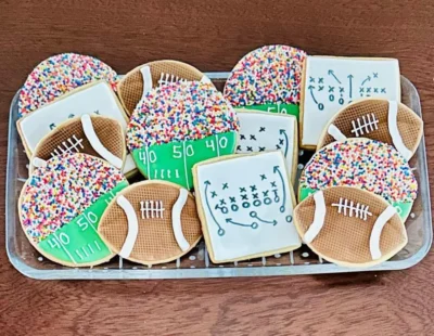 Football cookie, play diagram cookie and football stadium cookie on a plate