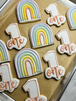 First birthday cookies with a rainbow and a number 1 with the word "one" below.